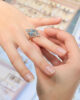 A girl trying a diamond ring on her finger