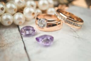 A golden ring resting on a pristine white wood background.